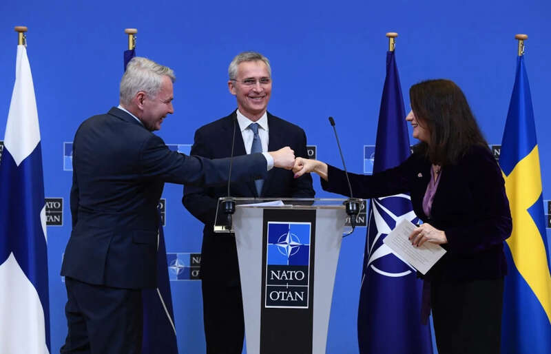 斯托尔滕贝格看着哈维斯托（左）和林德（右）碰拳