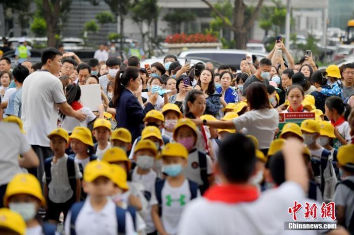 新生家长们目送学生进入校园
