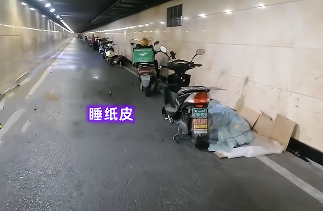 一名外卖小哥竟盖着被子和送外卖时穿的冲锋衣，睡在自己的电动车上