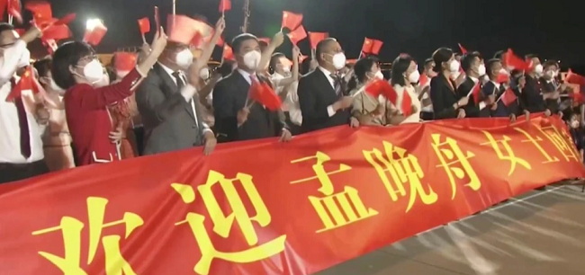 广东深圳宝安国际机场打着横幅欢迎孟晚舟回国的人群