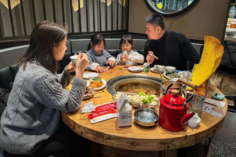 在沈阳市浑南区的山河屯铁锅炖饭店内品尝铁锅炖大鹅