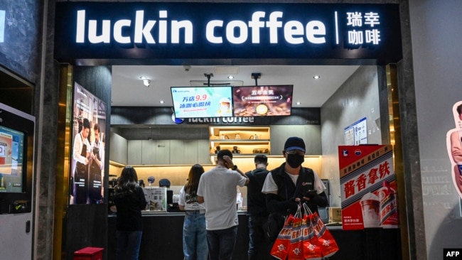 深圳一家华为商店的店员在向人们展示Mate 60系列手机