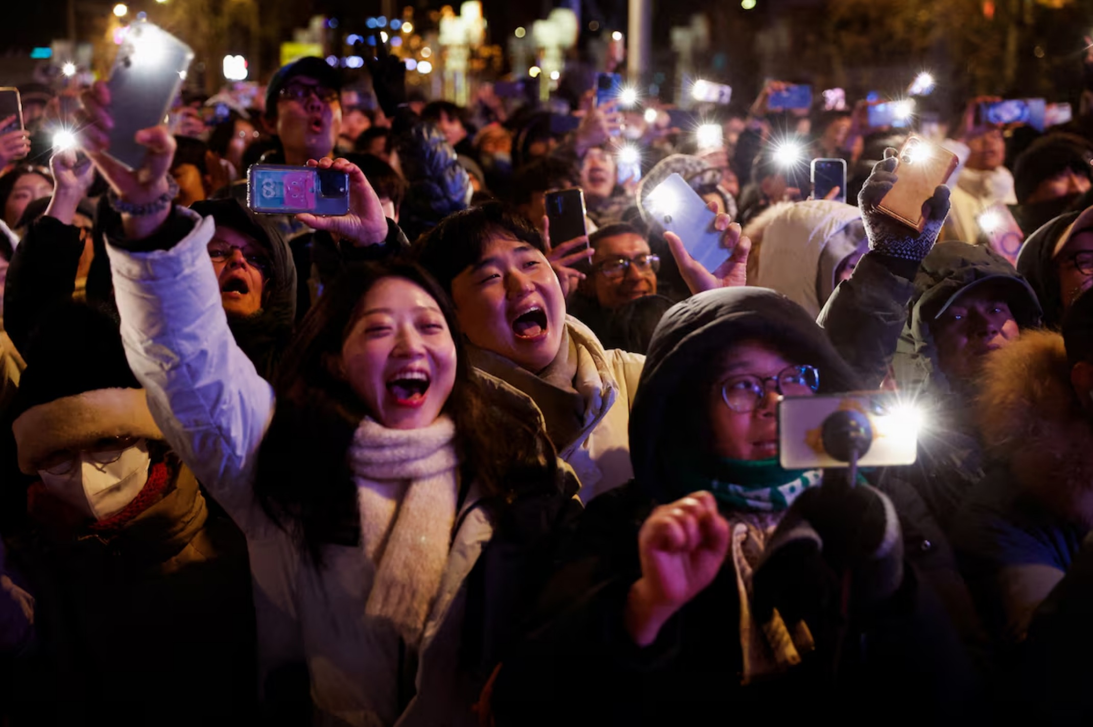 韩国首尔，人们手持手电筒，在午夜过后庆祝新年到来